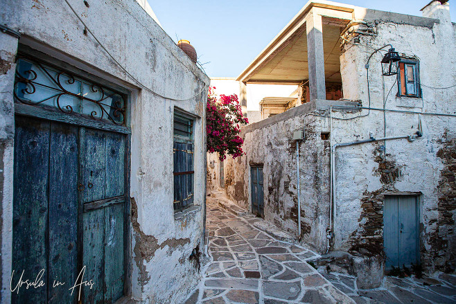 Narrow street of stone pavers lined by worn buildings, Lefkes Paros Greece.